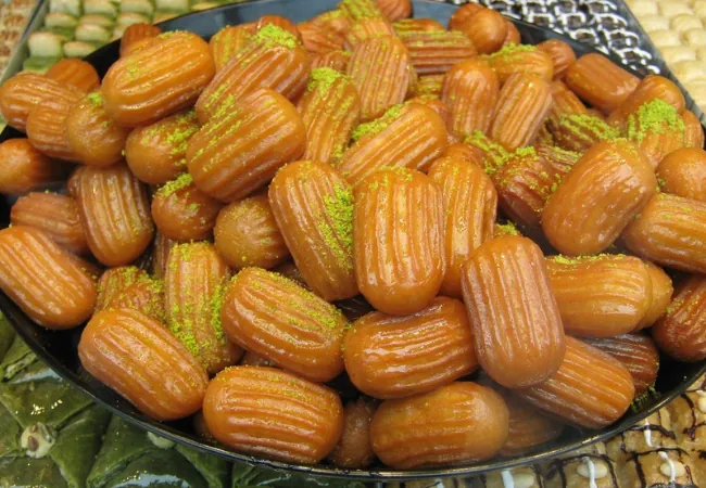 Turkish tulumba pastries soaked in syrup and garnished with pistachio